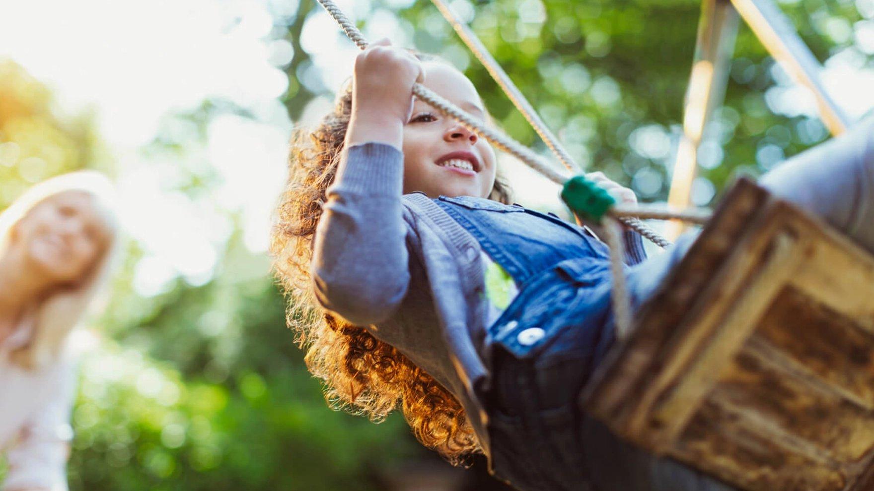 Niña jugando en un columpio al aire libre